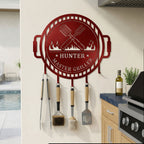 Candy apple red grill master metal tool organizer mounted beside outdoor grill with hanging barbecue accessories