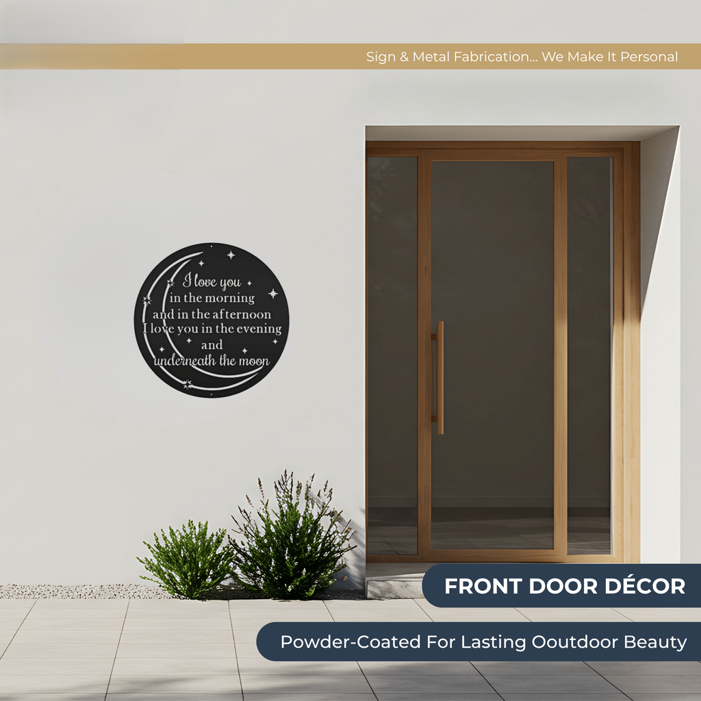 Outdoor entryway featuring a round black metal wall sign with romantic moon quote and star design mounted beside a modern wooden front door with powder coated weather resistant finish