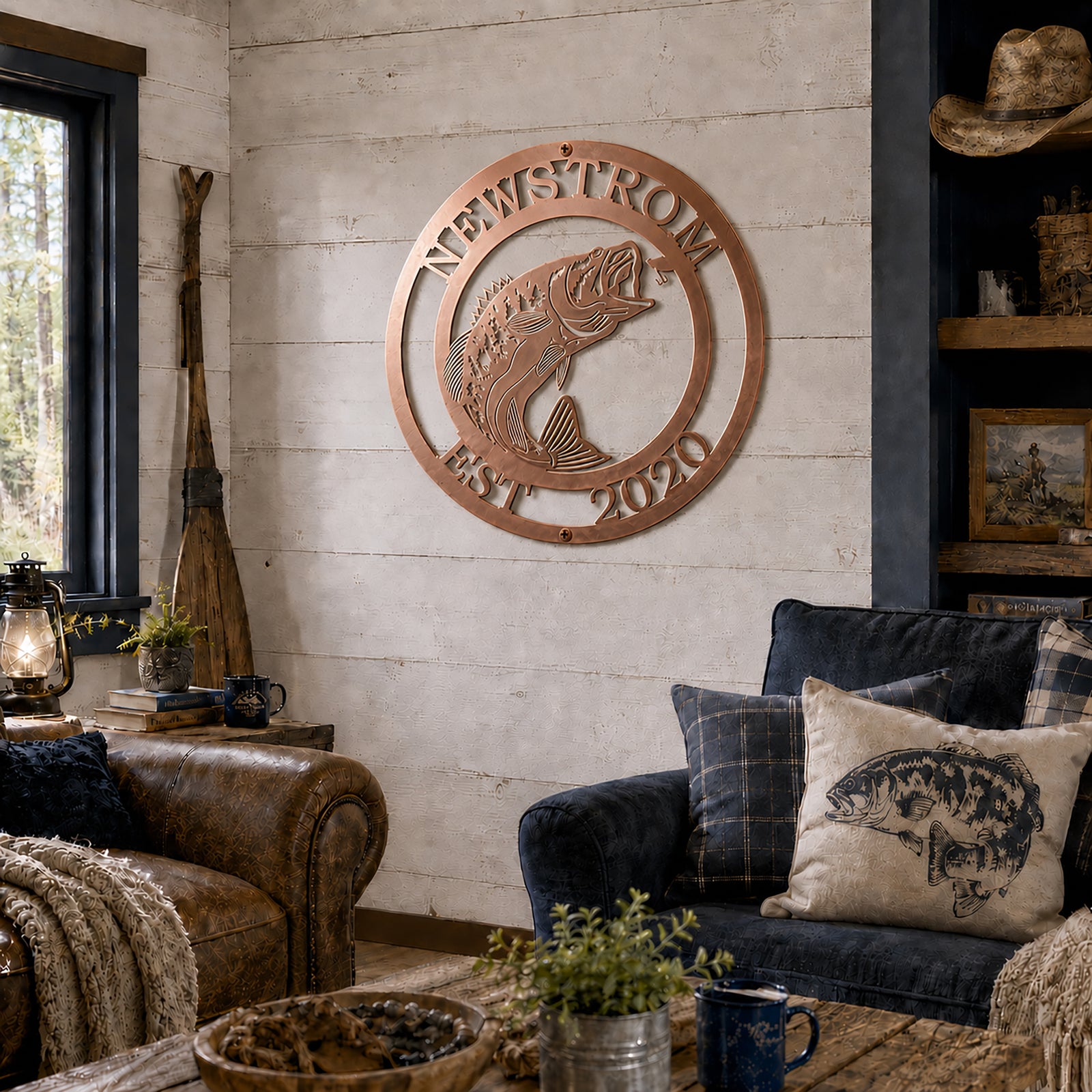 Rose gold bass fish metal wall sign with Newstrom and Est 2020 displayed in a rustic cabin living room