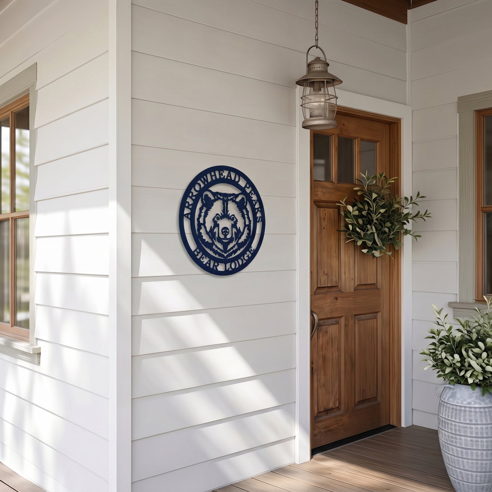 Arrowhead Peaks Bear Lodge metal wall sign displayed beside wooden front door on modern farmhouse style porch