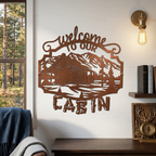 Copper welcome to our cabin metal sign with detailed mountain cabin design mounted on a cozy lodge style wall