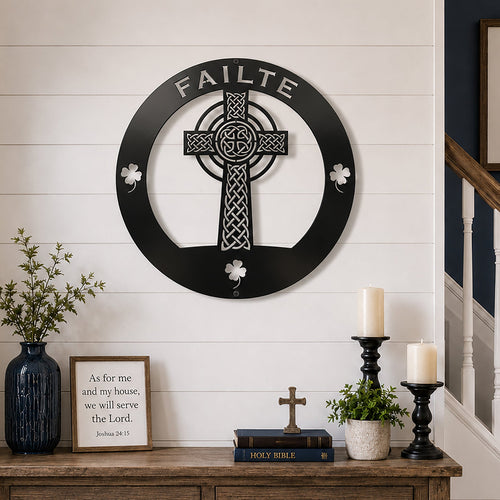 Black Celtic cross metal wall art with Failte welcome text displayed above a rustic wooden console table with Christian decor