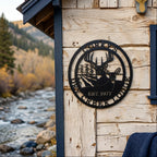 Black Corky’s Dry Creek Lodge metal wall plaque with buck doe and corn field design displayed on rustic cabin siding