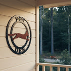 Fox den metal wall art with black circle frame and rust fox accent displayed on a light wood cabin wall near porch seating