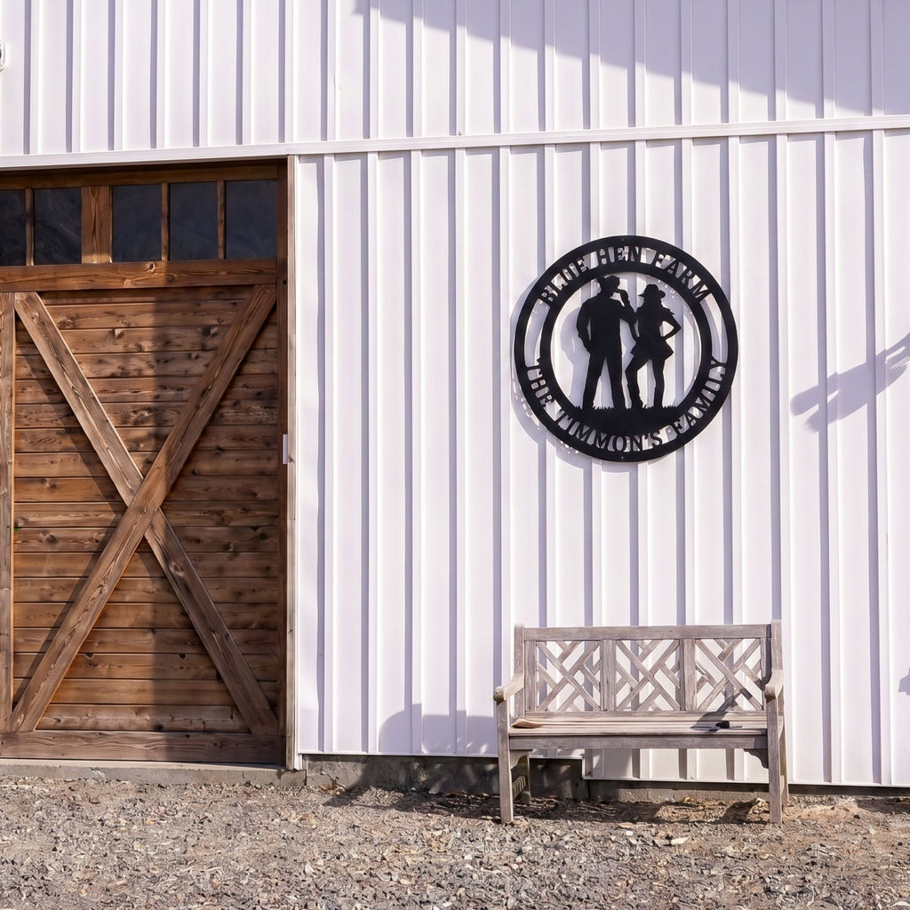 Personalized cowboy and cowgirl metal farm sign mounted on white barn wall beside wooden bench outdoors