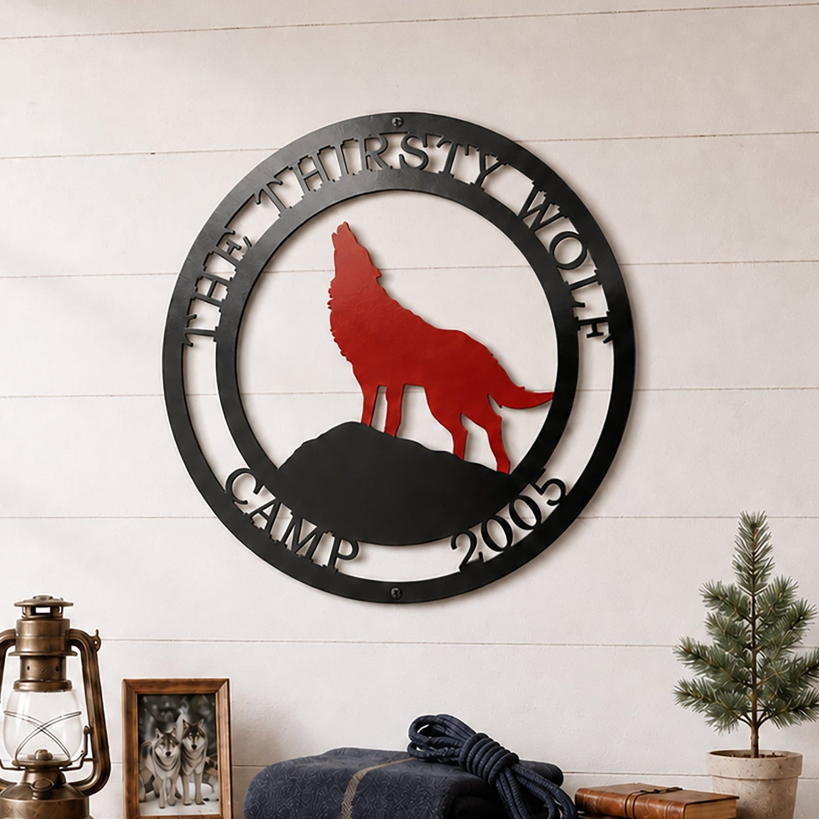 Custom wolf lodge metal wall décor displayed above wooden shelf with lantern books and cabin accessories