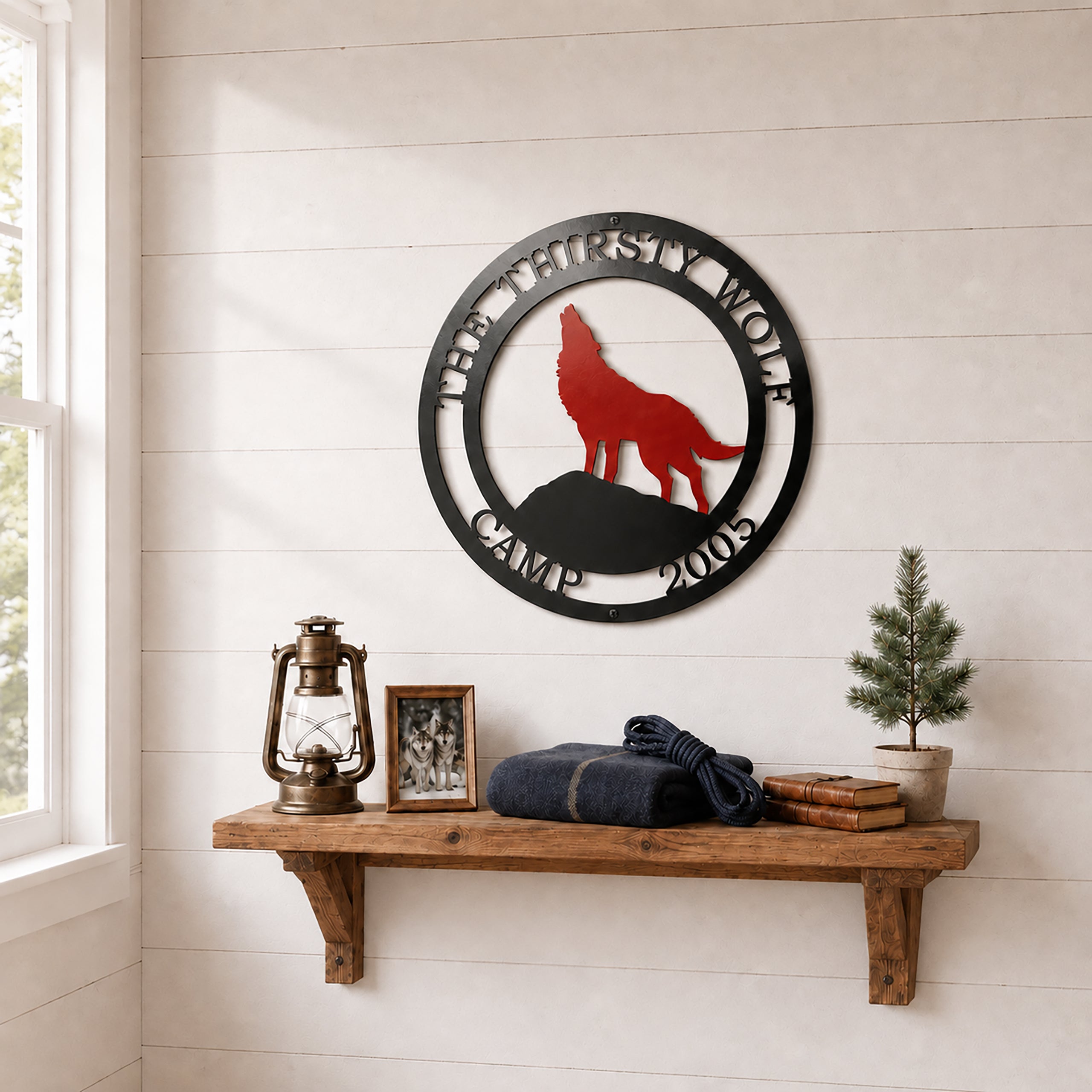 Custom wolf lodge metal wall décor displayed above wooden shelf with lantern books and cabin accessories