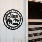 Black down at the farm metal sign with pigs and barn scene mounted near an outdoor pig enclosure