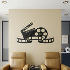 Satin black movie reel and clapperboard metal wall art above home theater seats