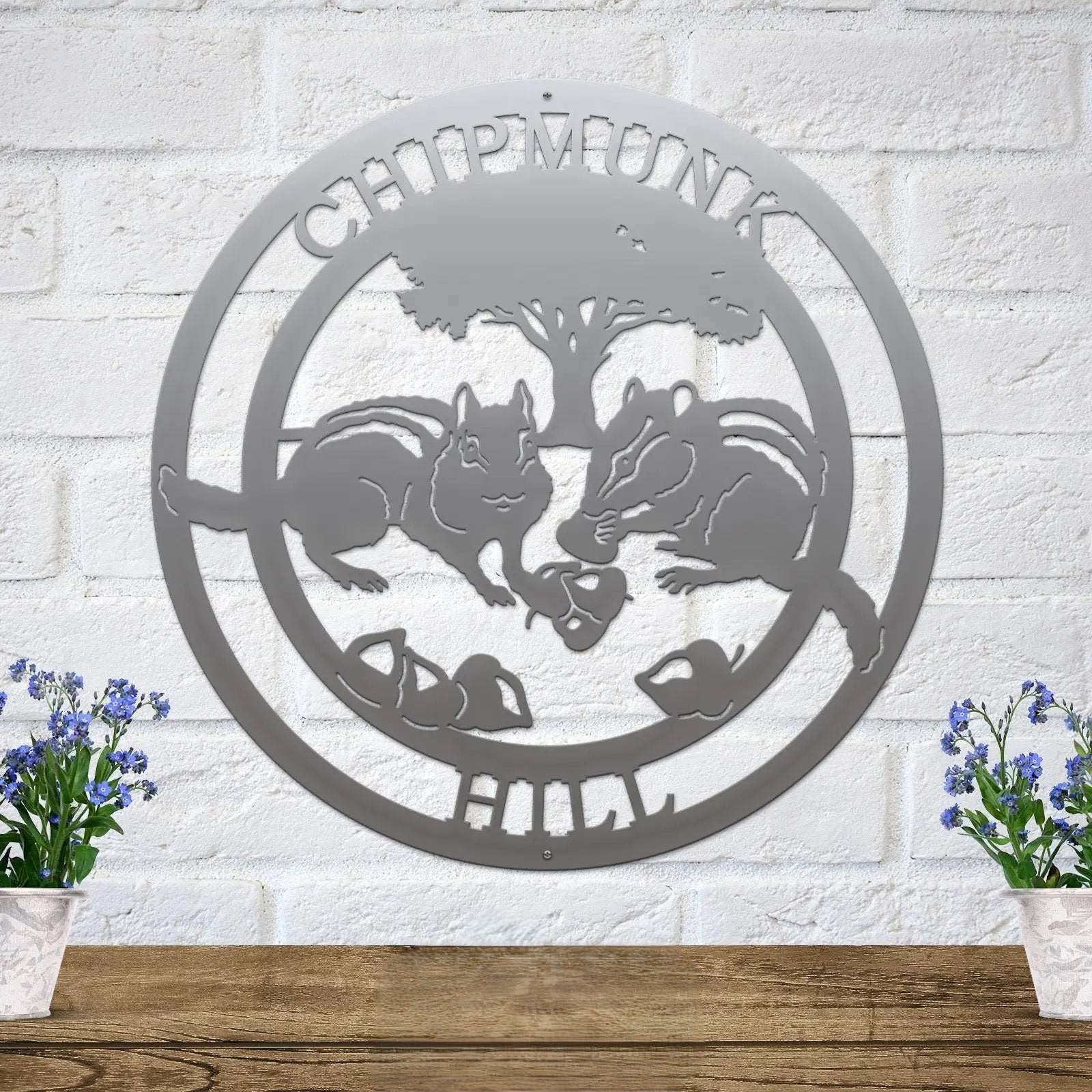Silver chipmunk hollow metal wall art with woodland animal and tree design mounted on white brick wall rustic cabin decor
