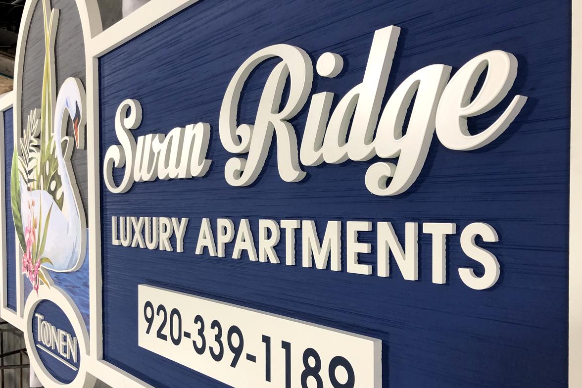 Close up of Swan Ridge luxury apartments dimensional HDU sign with raised lettering and decorative swan logo