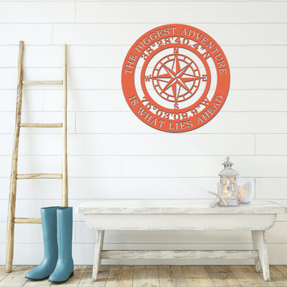 The Biggest Adventure Compass With Personalized GPS Coordinates metal sign, showcasing a compass design on a white wall, ideal for home or office decor, reflecting a spirit of exploration.