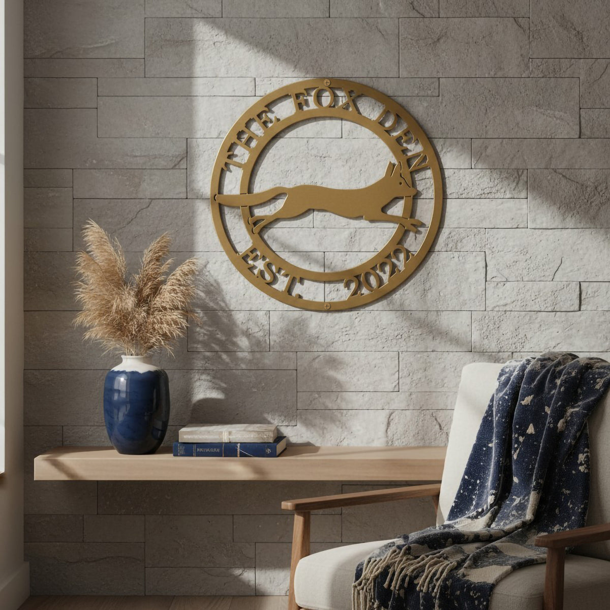 Gold The Fox Den metal wall art with running fox design mounted on a stone accent wall in a cozy reading nook