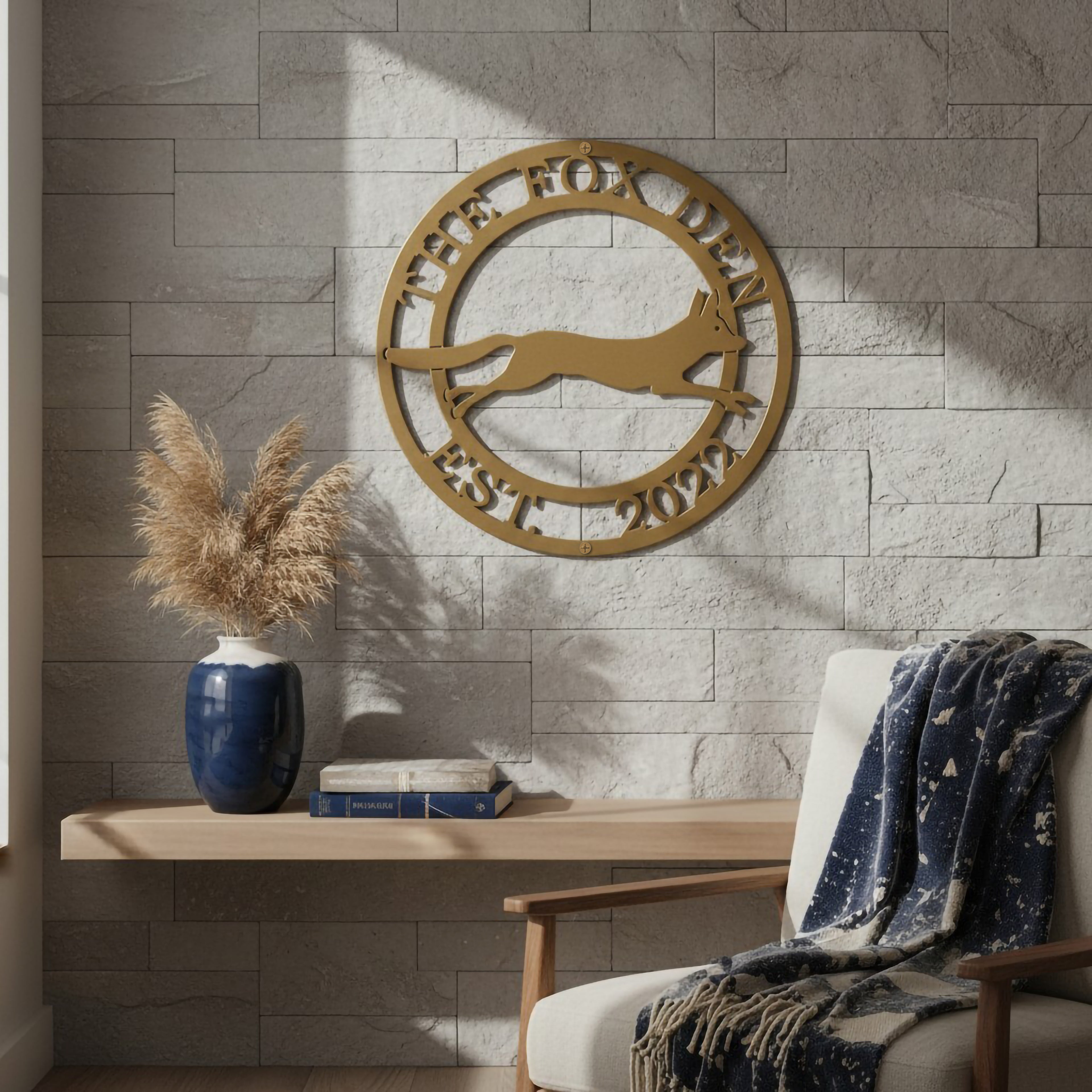Gold The Fox Den metal wall art with running fox design mounted on a stone accent wall in a cozy reading nook