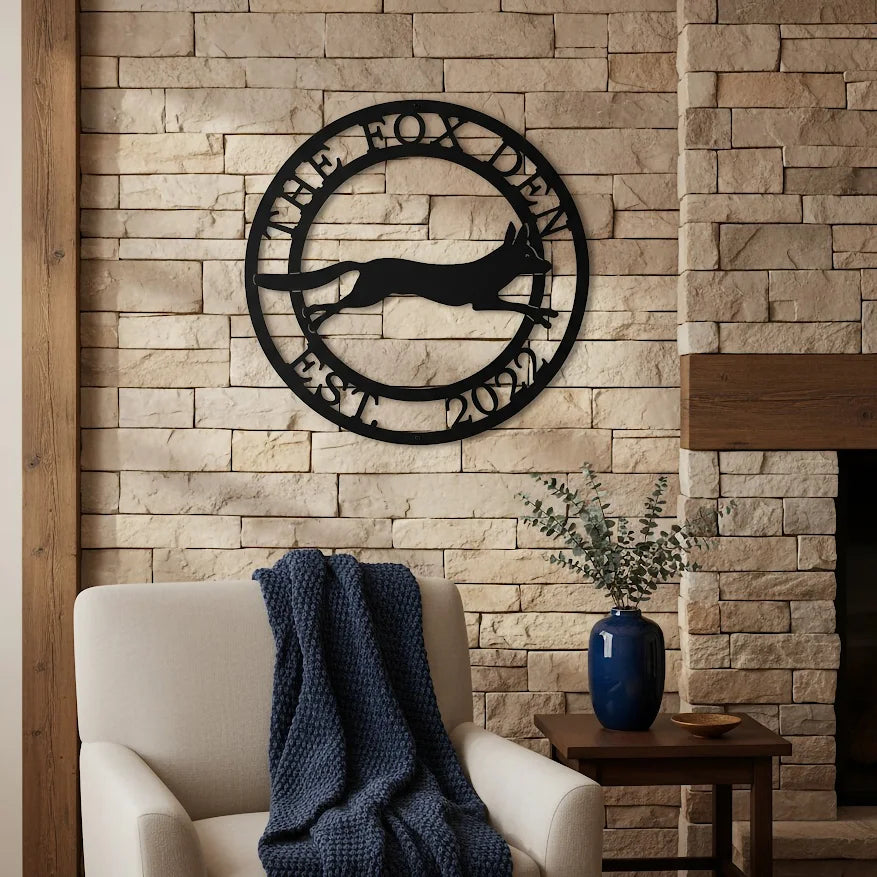 Black The Fox Den metal wall art with fox silhouette displayed on a stone fireplace wall above a cozy accent chair