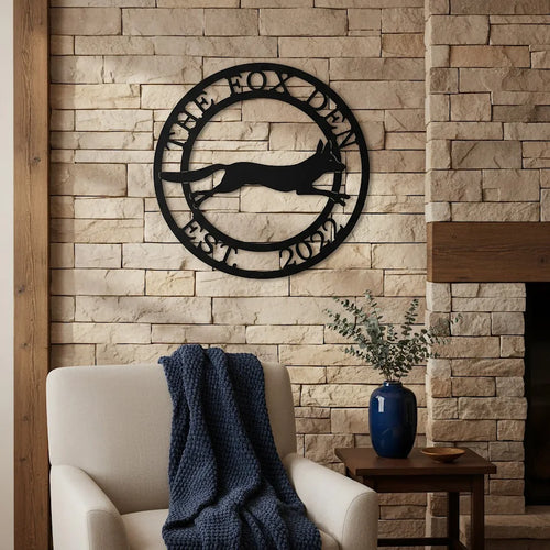 Black The Fox Den metal wall art with fox silhouette displayed on a stone fireplace wall above a cozy accent chair