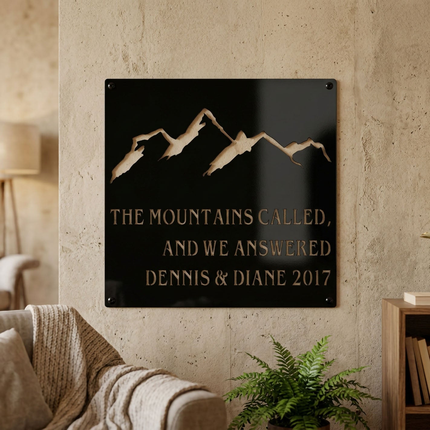 Custom mountain metal sign featuring mountain peak artwork and personalized family names with year, displayed as elegant wall décor in a modern living room setting.
