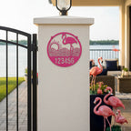 Sassy pink flamingo address plaque with number 123456 on lakeside gate pillar