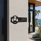 Black tropical palm tree metal address plaque with custom numbers mounted beside luxury beachfront home entrance
