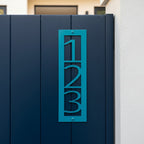 Teal blue vertical metal house number sign 123 mounted on a navy gate for modern outdoor address décor