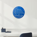 Royal blue custom metal moon and stars sign featuring romantic text styled on a plain white accent wall above a minimalist white office desk unit.
