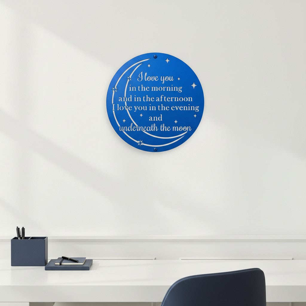 Royal blue custom metal moon and stars sign featuring romantic text styled on a plain white accent wall above a minimalist white office desk unit.
