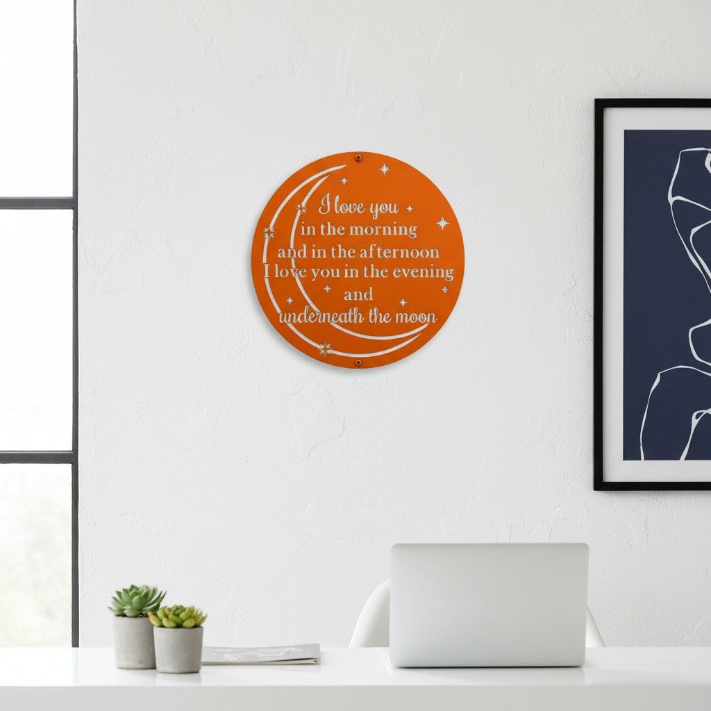 Bright orange personalized metal cutout sign featuring moon and stars typography hanging on a clean white office wall above a modern laptop setup.