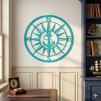 Bright turquoise custom metal compass anchor sign displayed on a white wall above beige wainscoting panels next to a dark blue library bookshelf unit.