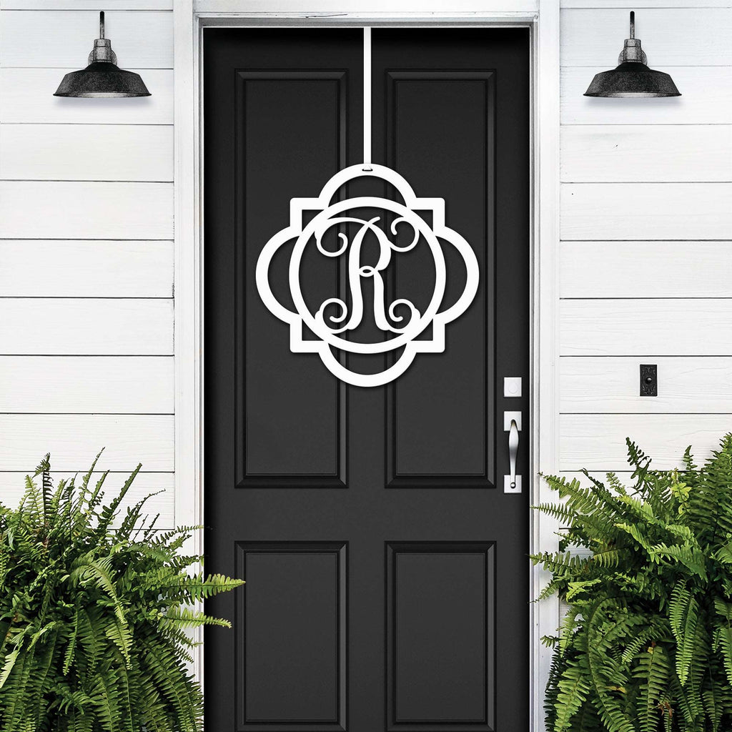 White monogram front door hanger with decorative letter R displayed on black door for custom porch entry decor