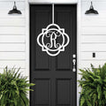 White monogram front door hanger with decorative letter R displayed on black door for custom porch entry decor