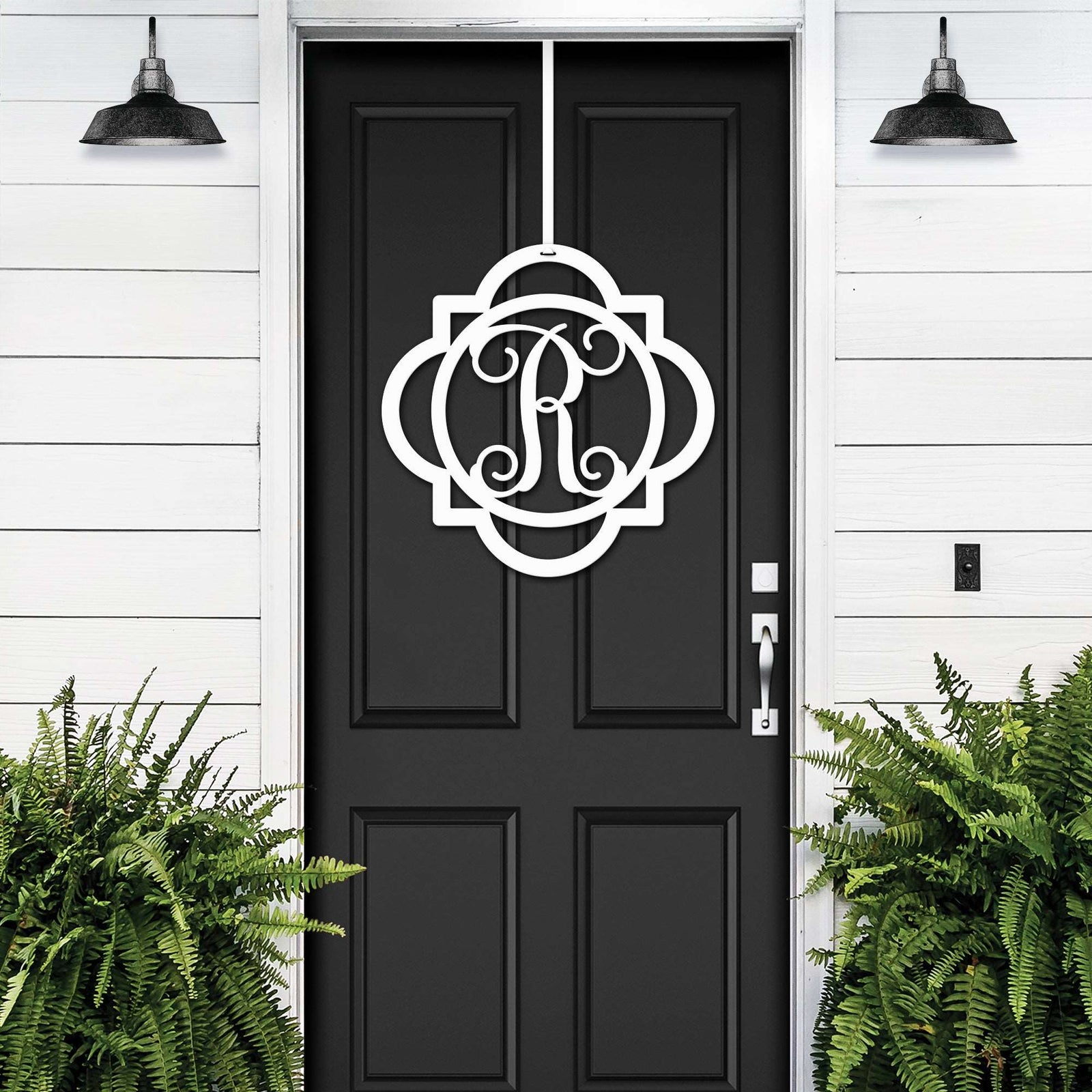 White monogram front door hanger with decorative letter R displayed on black door for custom porch entry decor
