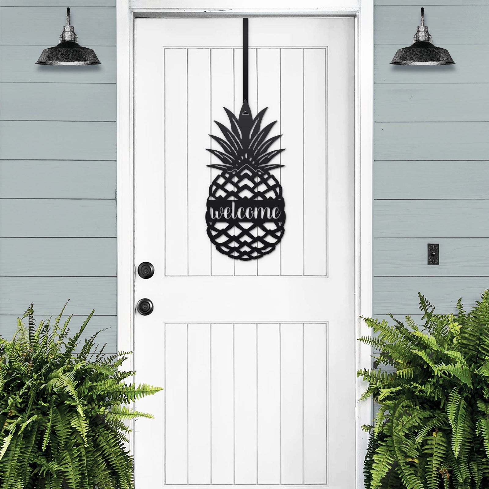 White pineapple welcome metal door sign displayed on black front door for classic porch welcome decor