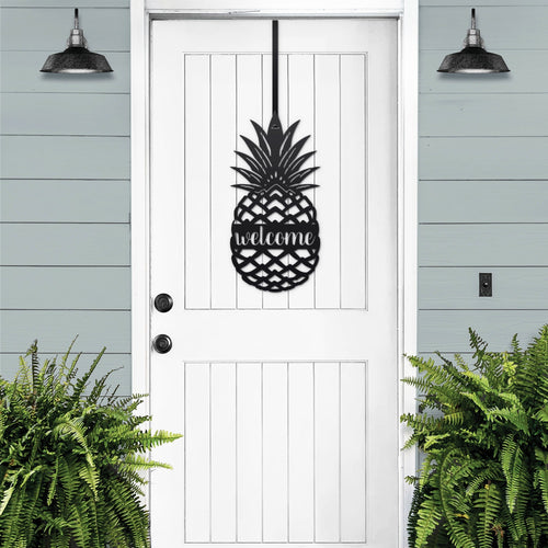 White pineapple welcome metal door sign displayed on black front door for classic porch welcome decor