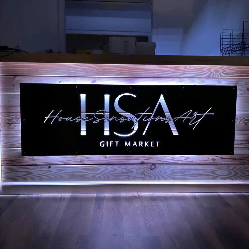 a wooden counter with a sign that reads "House Sensation Art Gift Market".