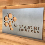 Custom LED office and storefront metal sign featuring “Spine & Joint Solutions” text, perfect for illuminated business branding, professional office décor, and outdoor signage.