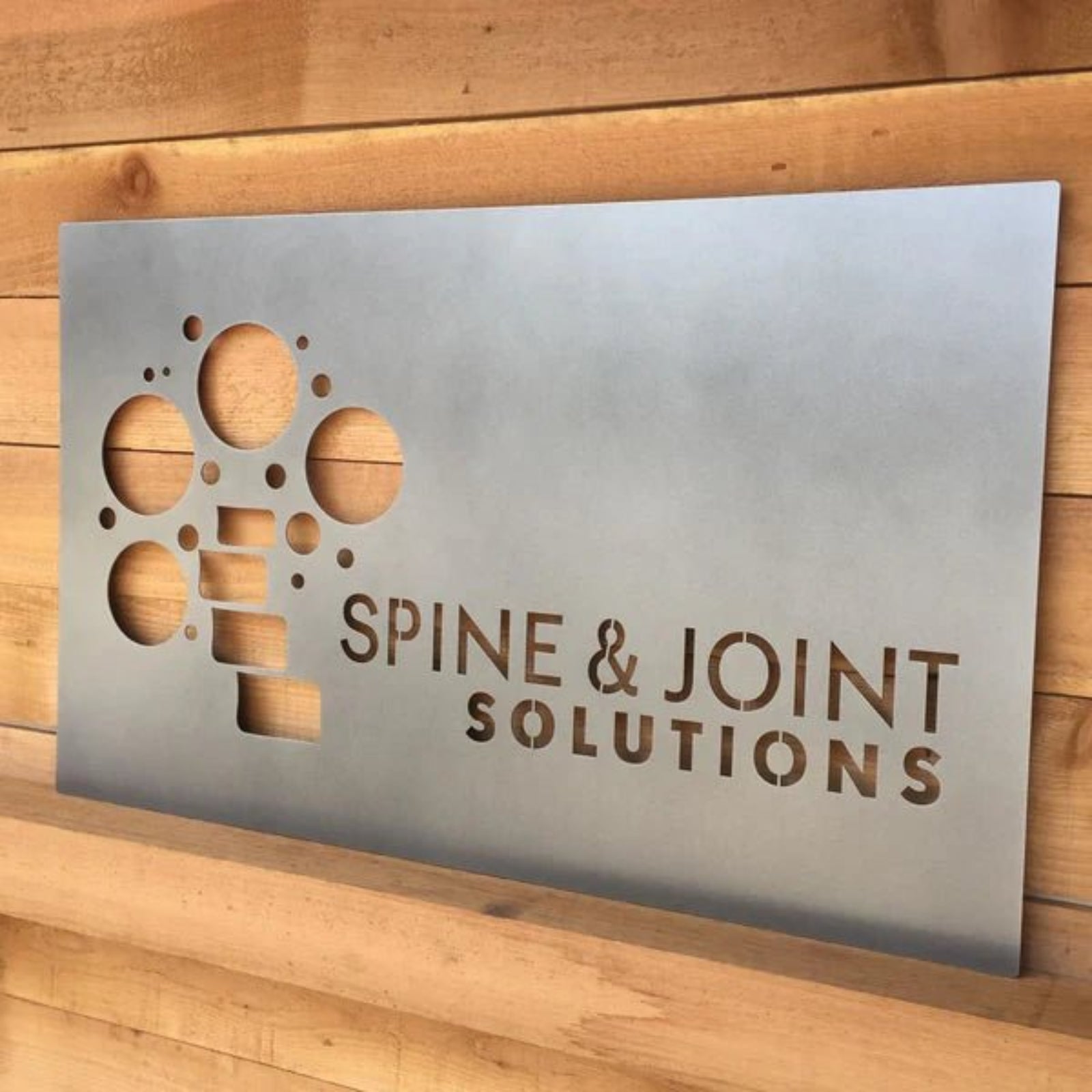 Custom LED office and storefront metal sign featuring “Spine & Joint Solutions” text, perfect for illuminated business branding, professional office décor, and outdoor signage.