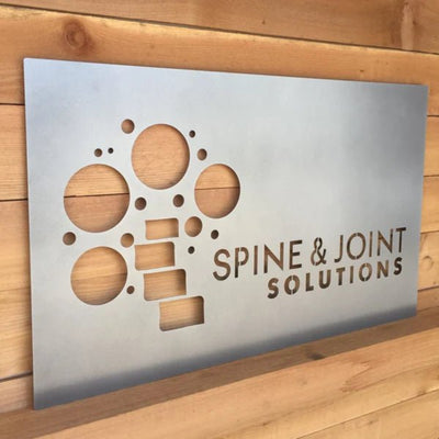 Affordable custom metal business logo sign featuring “Spine & Joint Solutions” text, precision laser-cut from 16-gauge steel, ideal for office branding, storefront signage, and professional business décor.