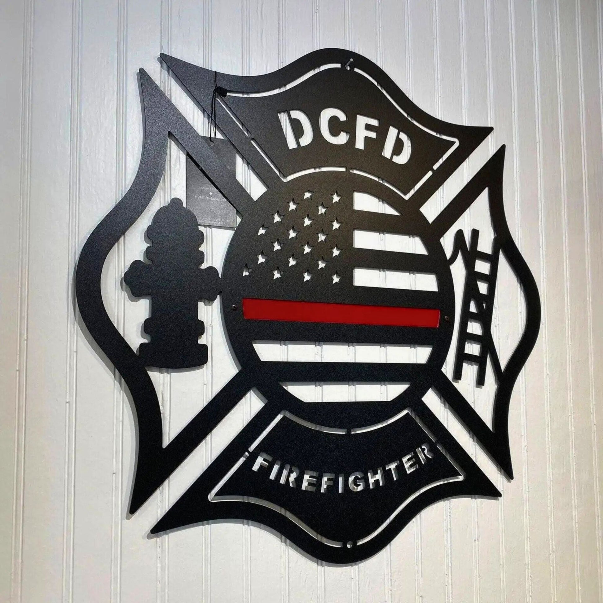 Personalized Maltese Cross firefighter metal wall art with “DCFD” text and emblem on wooden background, American flag design, HouseSensationsArt