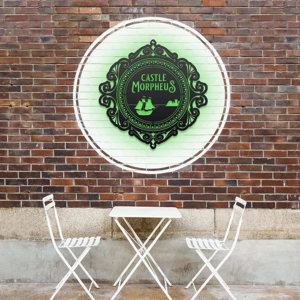 Black circular sign with green LED on a brick wall features “CASTLE MORPHEUS” text and ship and castle illustrations.