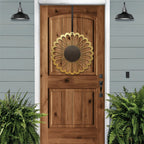 Sunflower metal wreath on wooden front door, bright floral circular design, light blue house exterior, handcrafted outdoor metal decor, modern entryway art