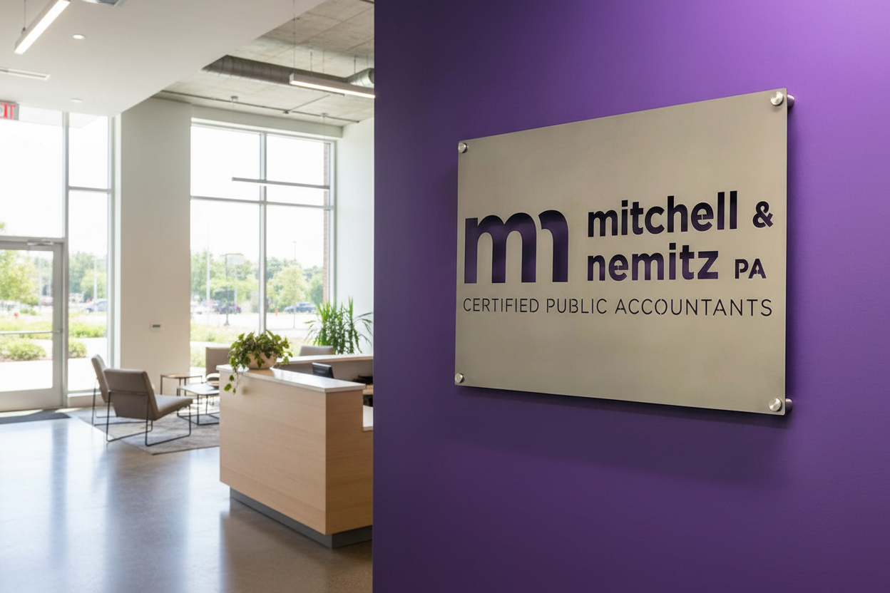 Custom metal office and storefront sign featuring laser-cut “Mitchell & Nemitz PA” logo on a vibrant purple wall in a professional office space.
