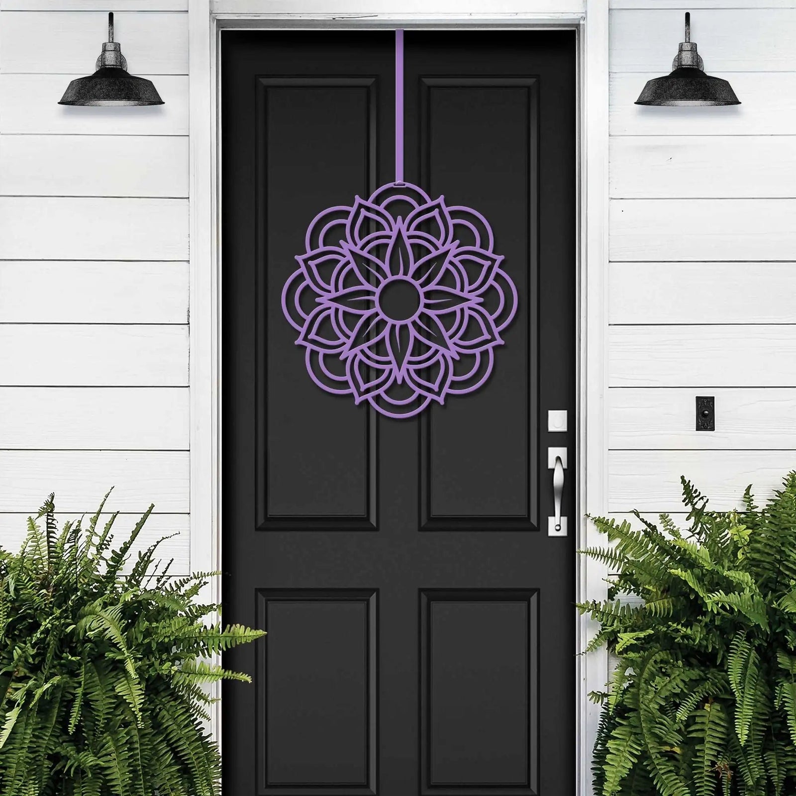 Purple cascading floral wreath on black door, elegant door decor for events, white wall exterior with lush green plants, garden home art
