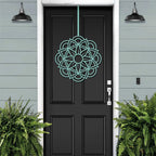 cascading floral wreath door decor, green botanical pattern, black door on light blue house exterior, garden home styling, event decor