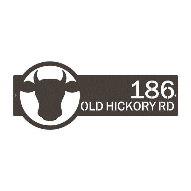 Close-up of oil-rubbed bronze address sign featuring cattle head emblem on the right and house number '186 Old Hickory Rd' on the left.