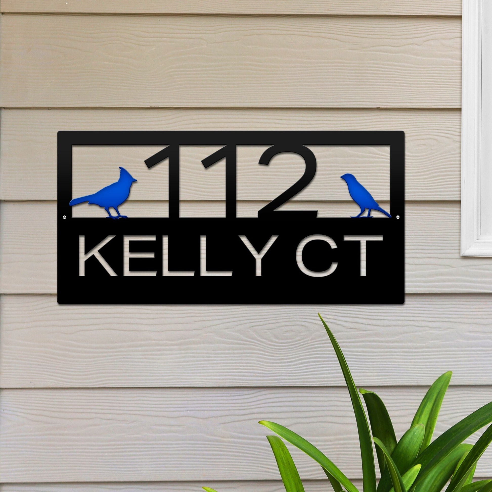 Black Classic Cardinal Address Sign featuring a blue cardinal on each side, house number '112' in the center, and 'Kelly CT' below.