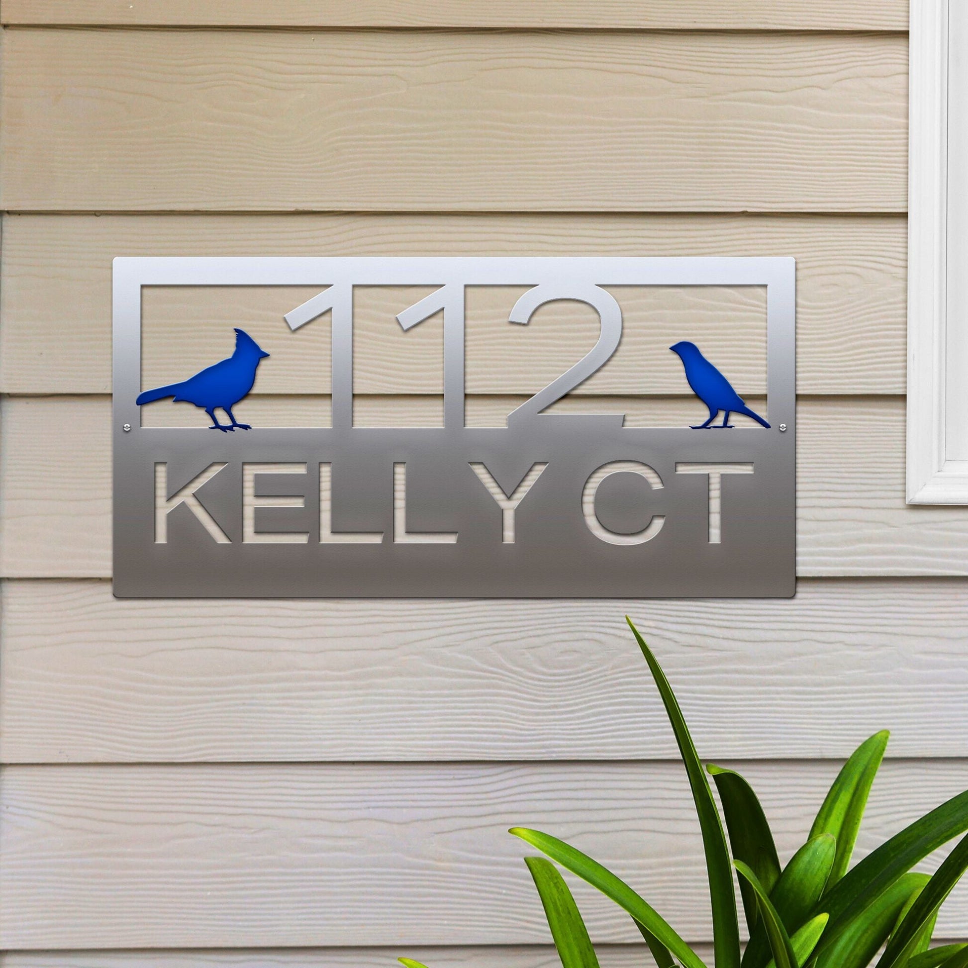 Polished Chrome Classic Cardinal Address Sign featuring a blue cardinal on each side, house number '112' in the center, and 'Kelly CT' below.