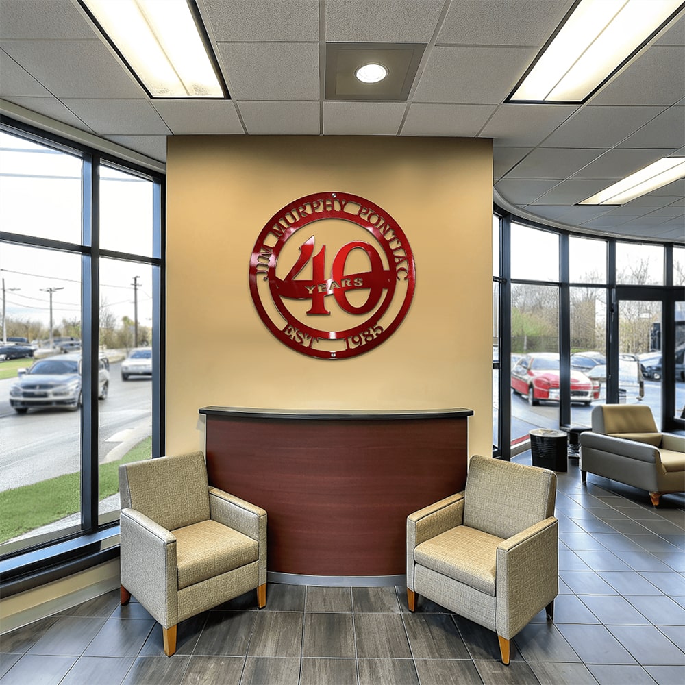 Custom metal business anniversary sign reading “40 Years,” displayed on car dealership interior wall, decorative corporate milestone décor, HouseSensationsArt
