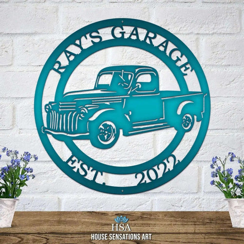 Teal metal Chevy sign with vintage truck design and “Ray's Garage” text on white brick wall, front door outdoor plaque, automotive décor