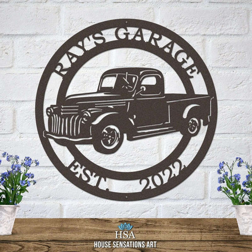 Decorative metal sign with vintage truck design and “Ray's Garage” text on white brick wall, front door outdoor plaque, automotive décor