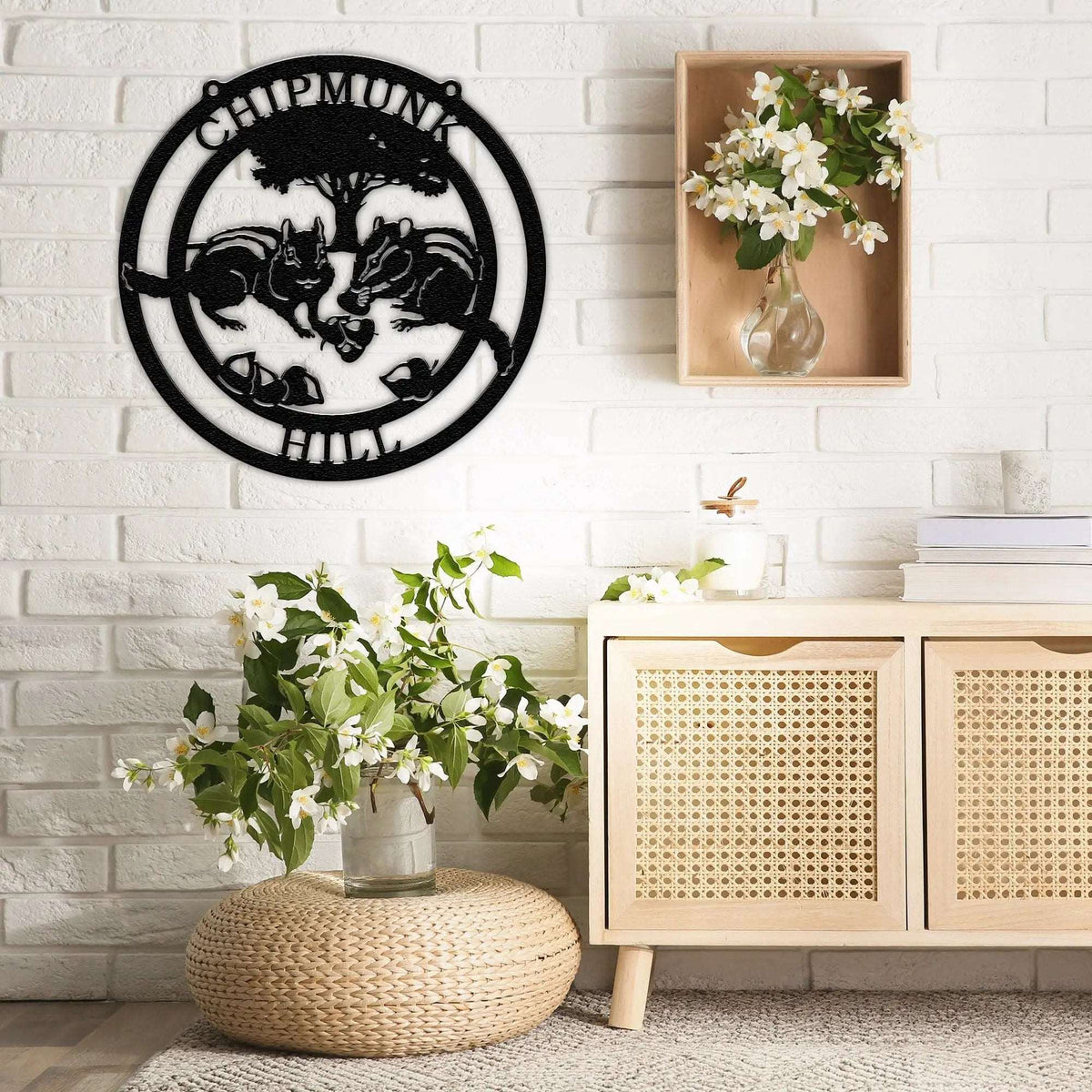 Custom metal Chipmunk Crossing wall sign with "Chipmunks" text, decorative indoor wall art mounted on white brick, displayed above wooden cabinet with vase of flowers